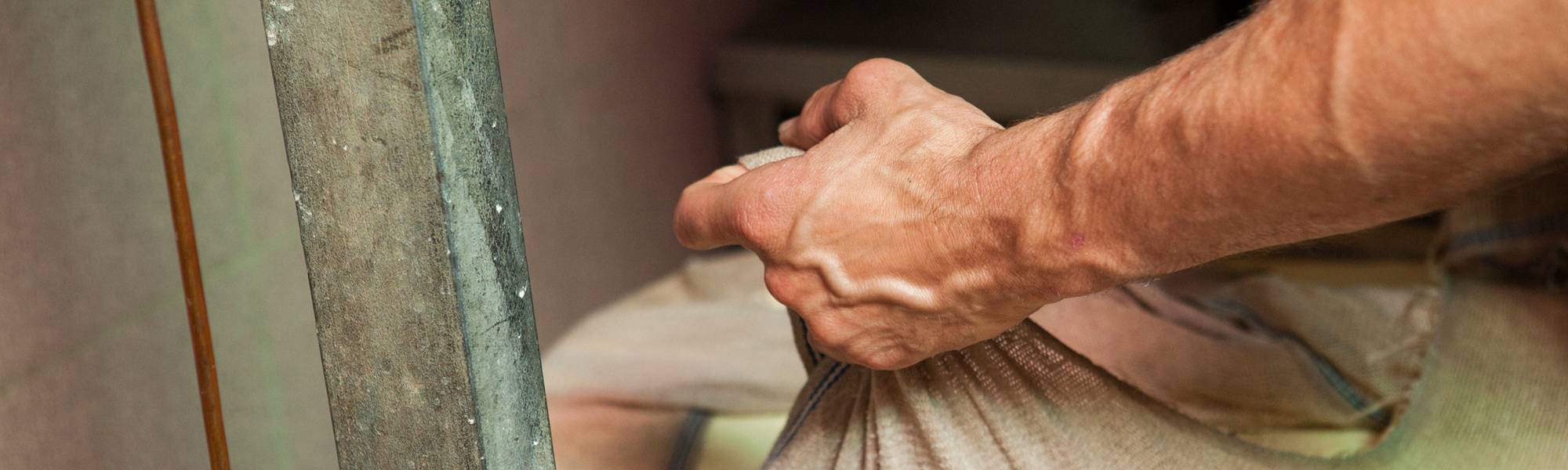 Les mains de Nicolas tenant le tissu contenant le fromage Etivaz